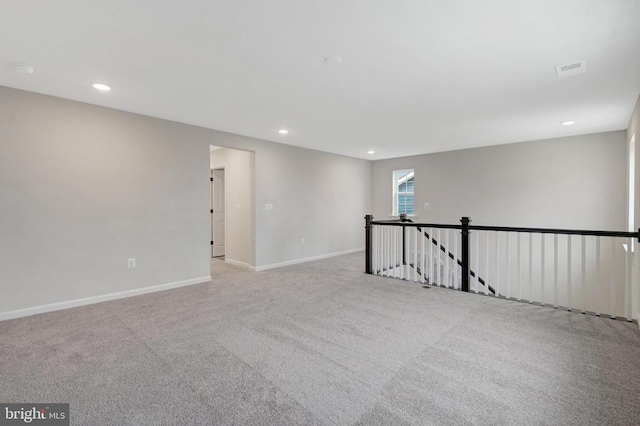 empty room featuring recessed lighting, light colored carpet, visible vents, and baseboards