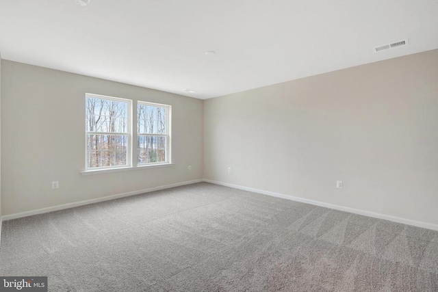 empty room featuring light carpet, baseboards, and visible vents