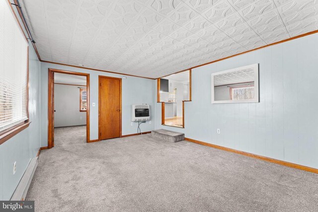 carpeted spare room with crown molding and heating unit