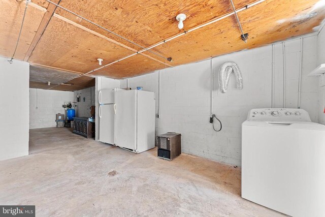 basement with washer / clothes dryer and white refrigerator