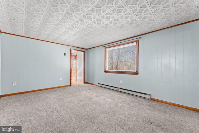 spare room with a baseboard radiator, ornamental molding, and carpet