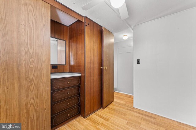 hallway with wooden walls and light hardwood / wood-style flooring