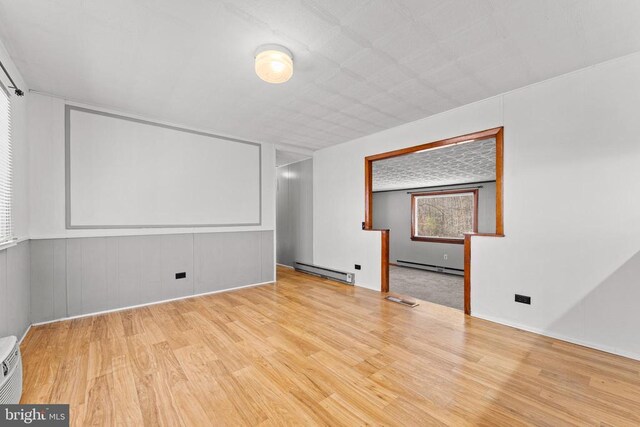 spare room featuring light hardwood / wood-style flooring and baseboard heating