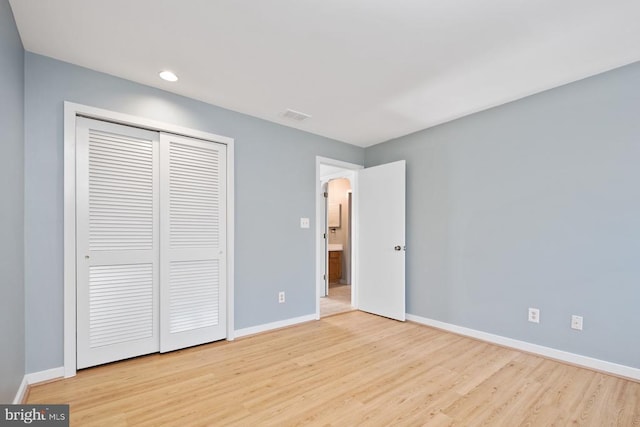 unfurnished bedroom with arched walkways, wood finished floors, visible vents, and baseboards