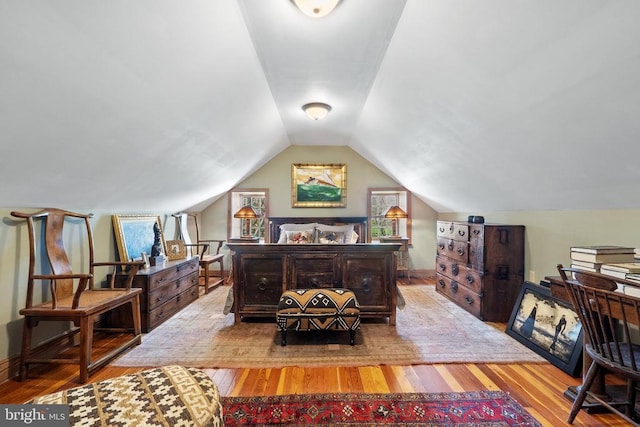 bedroom with wood finished floors and vaulted ceiling