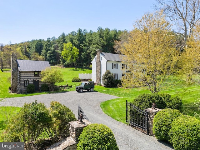 view of community with fence, a yard, and a gate