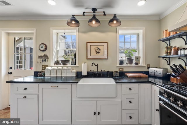 kitchen featuring open shelves, a sink, dark countertops, visible vents, and oven