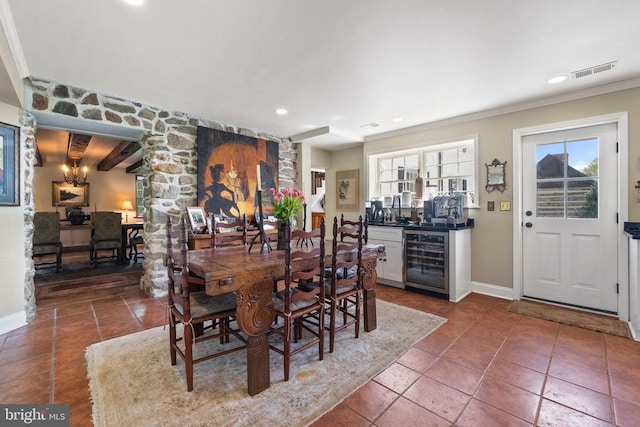dining room featuring wine cooler, crown molding, visible vents, and baseboards
