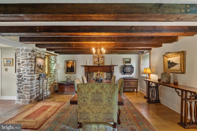 dining area with beam ceiling, wood finished floors, and baseboards