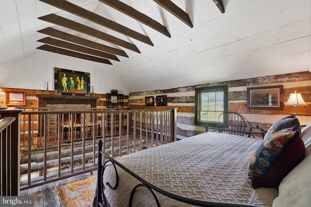 bedroom with lofted ceiling with beams, wooden walls, and wood finished floors
