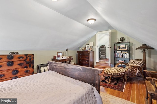 bedroom with lofted ceiling and wood finished floors