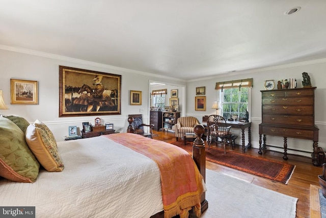 bedroom with crown molding and wood finished floors
