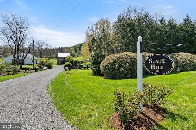 view of community featuring fence and a yard