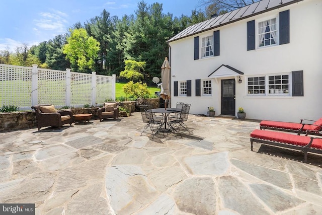 view of patio featuring outdoor dining space and fence
