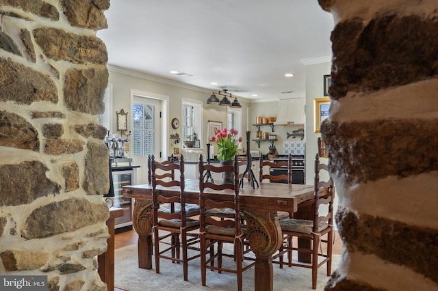 dining room featuring crown molding, recessed lighting, and light wood-type flooring