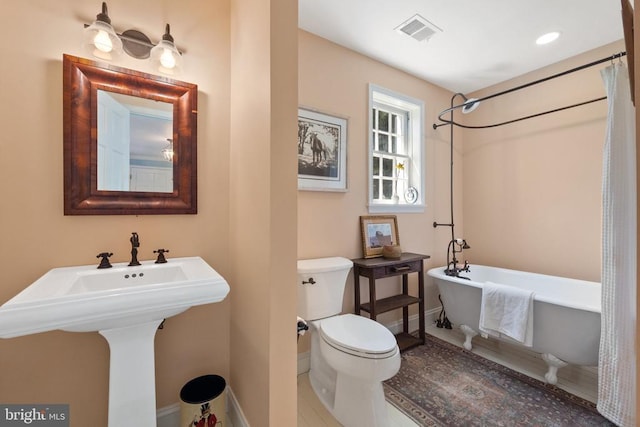 bathroom featuring walk in shower, a freestanding bath, toilet, baseboards, and visible vents