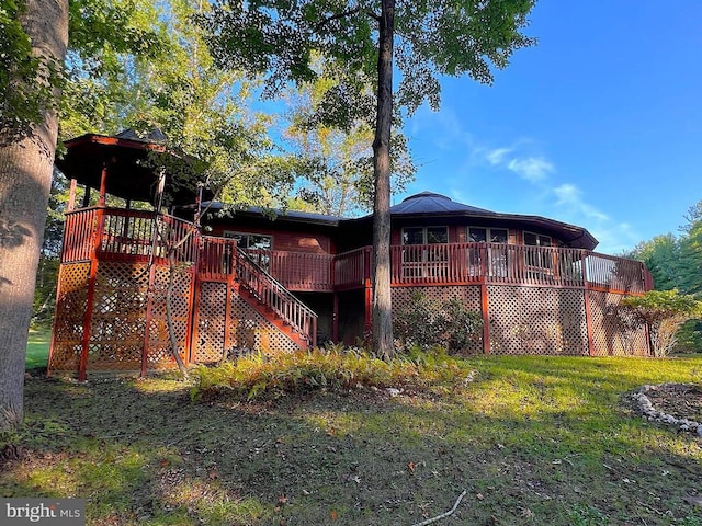 back of property with stairway, a lawn, and a wooden deck