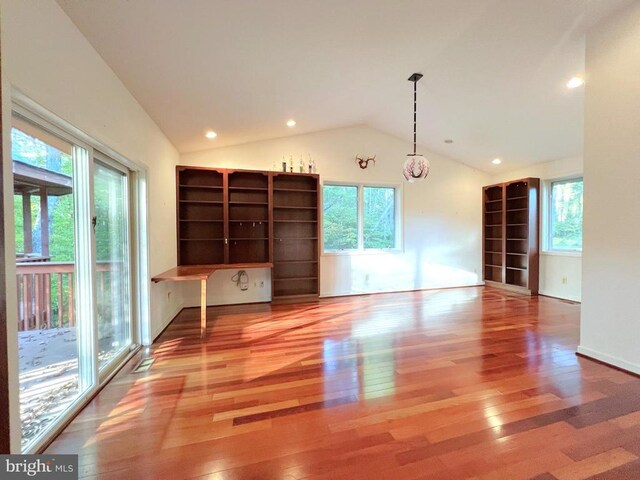 unfurnished living room featuring lofted ceiling and wood-type flooring