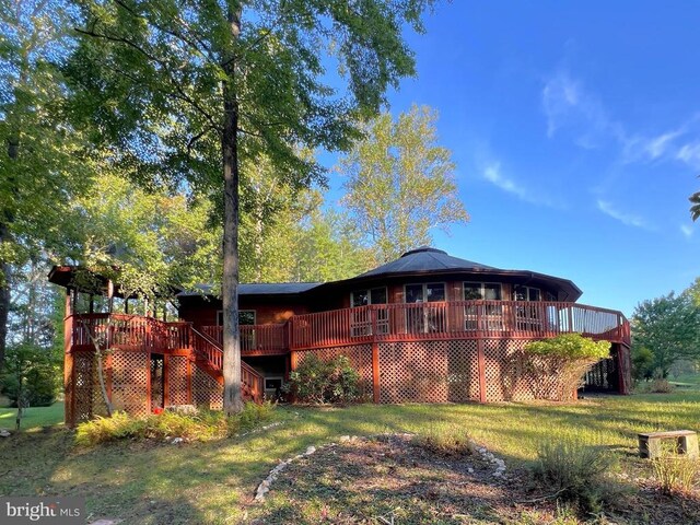 exterior space featuring stairway, a lawn, and a wooden deck