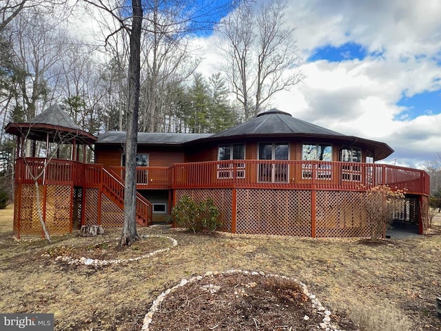 rear view of house featuring a gazebo, a wooden deck, and stairs