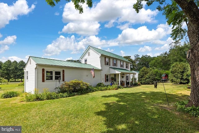 rear view of property with a yard and metal roof