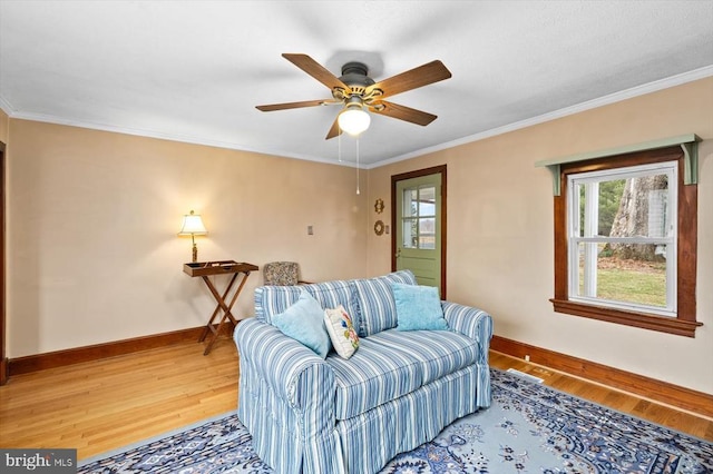 living room with ceiling fan, light wood-type flooring, baseboards, and ornamental molding