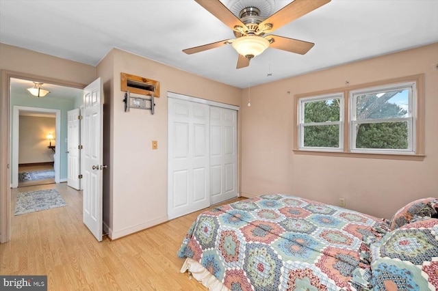 bedroom featuring a closet, baseboards, light wood-style floors, and a ceiling fan