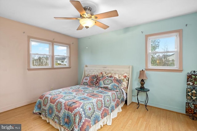 bedroom with baseboards, wood finished floors, and a ceiling fan