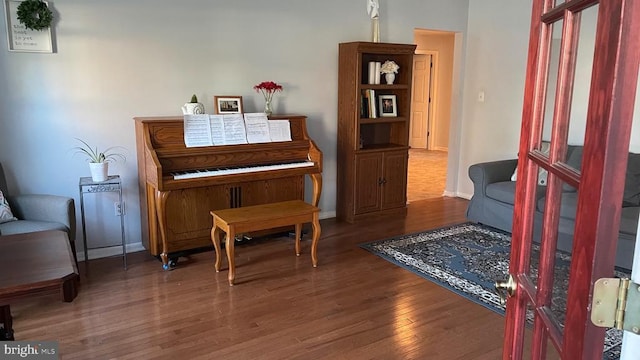 sitting room with baseboards and wood finished floors