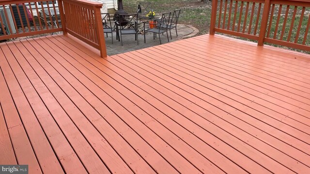 wooden deck featuring outdoor dining area and a patio