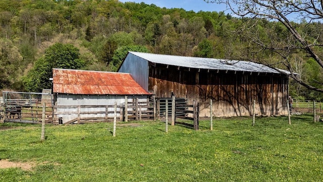 view of stable featuring a forest view