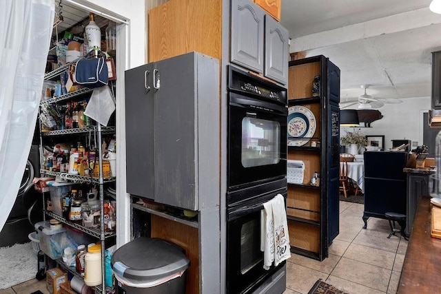 kitchen with a ceiling fan, dobule oven black, and light tile patterned flooring