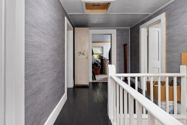 hall with dark wood-style floors, an upstairs landing, and wallpapered walls