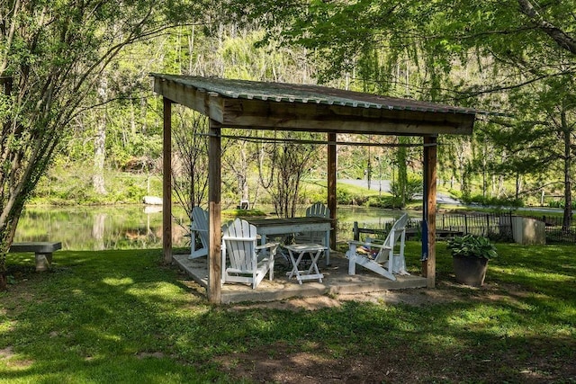 view of outbuilding featuring a gazebo, a water view, and a wooded view