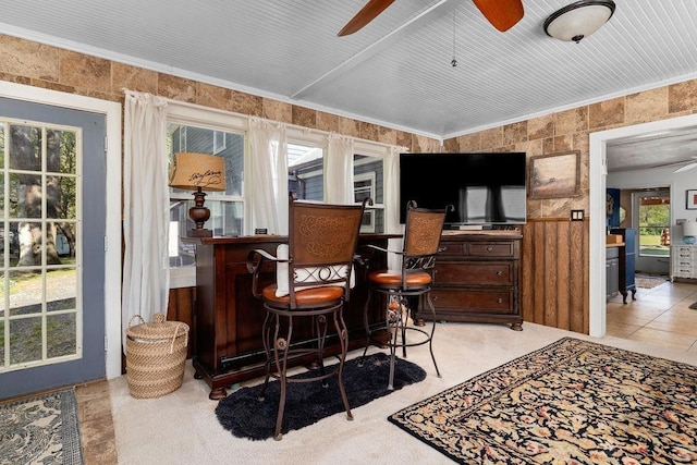 bar with a bar, ceiling fan, and a wainscoted wall