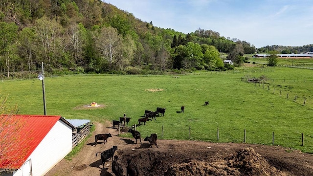 view of community with an outdoor structure, an exterior structure, fence, and a rural view