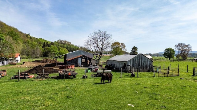 view of yard featuring fence, a pole building, and an outbuilding