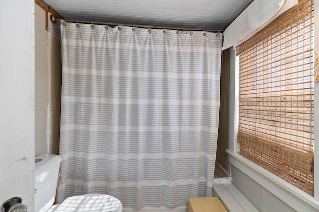 full bath with curtained shower and toilet