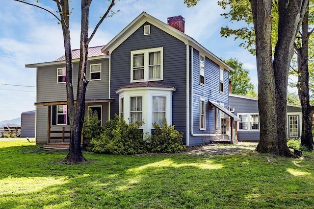 view of front of house featuring a front lawn and a chimney