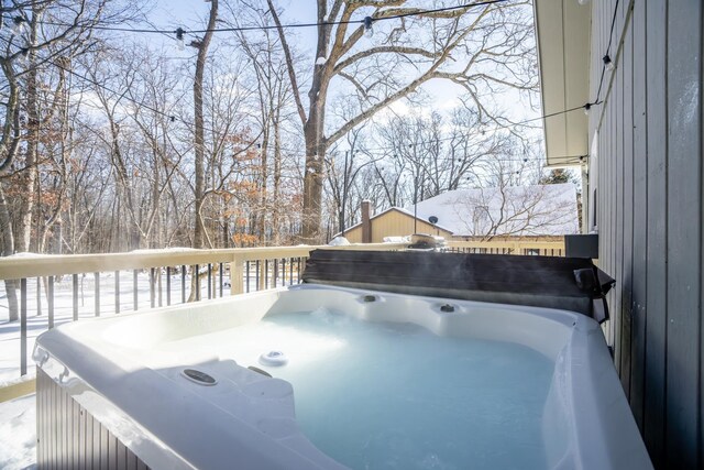 snow covered deck with a hot tub