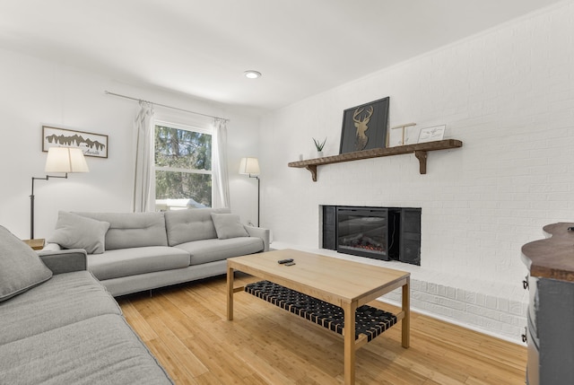 living room featuring hardwood / wood-style flooring and a brick fireplace