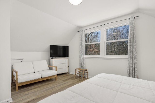 bedroom with vaulted ceiling and hardwood / wood-style floors