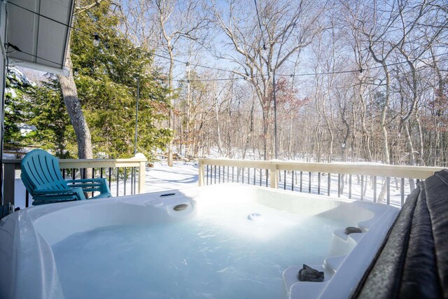 snow covered deck with a hot tub