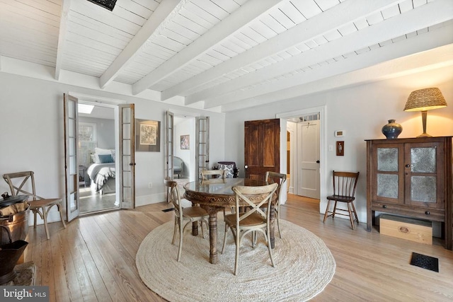 dining room with light hardwood / wood-style flooring, french doors, wooden ceiling, and beam ceiling