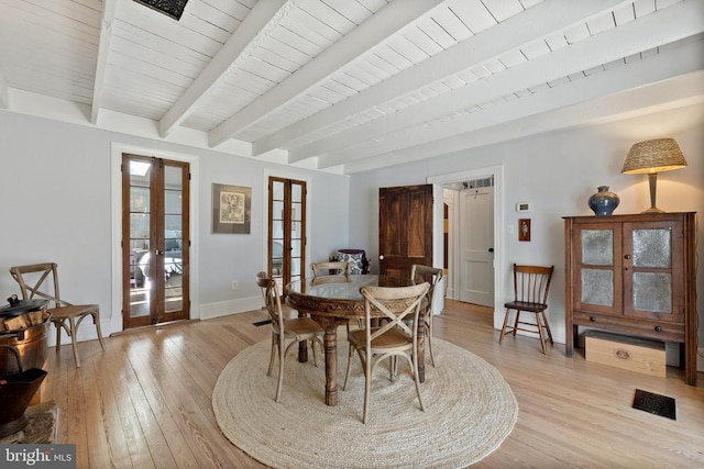 dining space with light wood-type flooring, french doors, beamed ceiling, and wooden ceiling