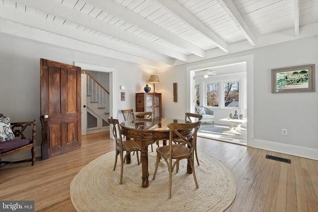 dining area with hardwood / wood-style flooring, wooden ceiling, and beam ceiling