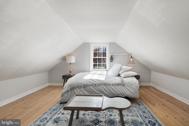 bedroom featuring hardwood / wood-style flooring and vaulted ceiling