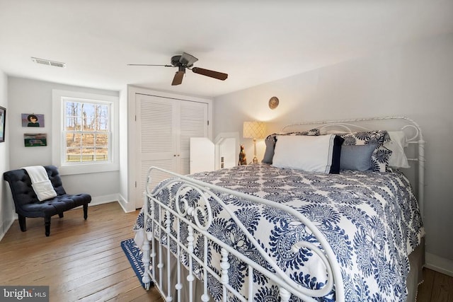 bedroom with hardwood / wood-style flooring, ceiling fan, and a closet