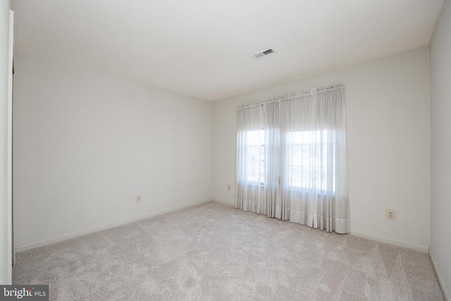 unfurnished room with carpet floors and visible vents