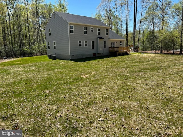 rear view of house featuring central AC unit, a yard, and a deck